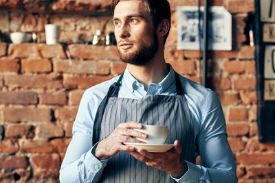 Young man drinking coffee at cafe