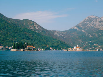 Scenic view of sea by townscape against sky