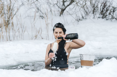 Portrait of boy drinking water on snow