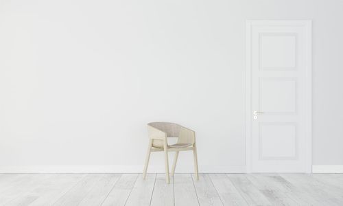 Empty chair against white wall