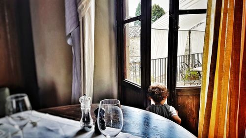 People sitting on table by window at home