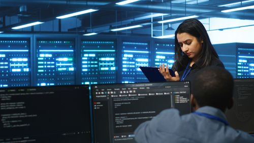 Portrait of young woman using mobile phone in office