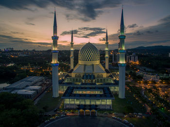 Communications tower in city against sky