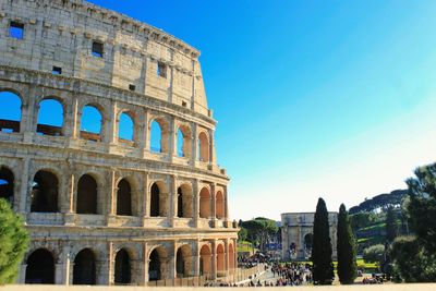 Low angle view of coliseum against clear sky