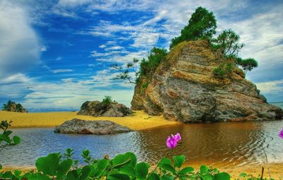 Rock formations by sea against sky