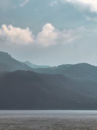 Scenic view of sea and mountains against sky