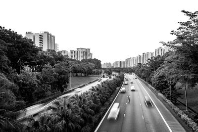 Cars on road in city against clear sky