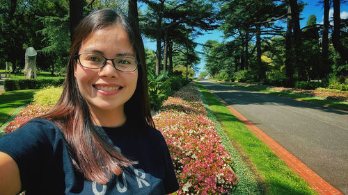 Portrait of smiling woman standing by road