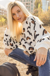 Portrait of beautiful woman crouching on field