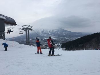 People on snow covered mountain against sky