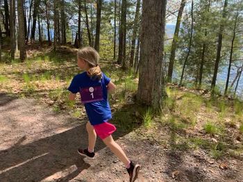 Full length of boy running in forest