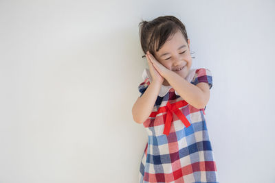 Cute girl standing against white background