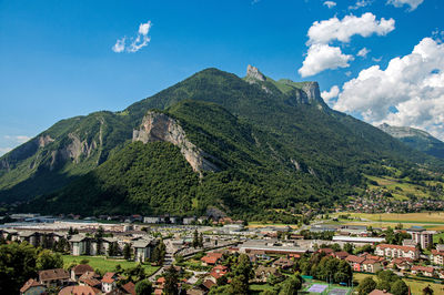 Houses in valley with evergreen mountains viewed from the faverges castle, france.