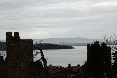 Scenic view of sea by buildings against sky