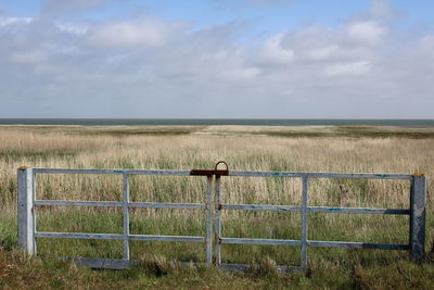 Fence on field against sky