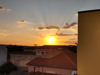 Buildings in town against sky during sunset