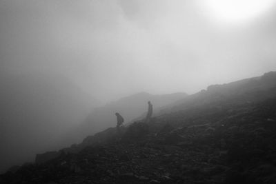 People on mountain against sky