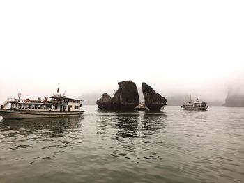 Scenic view of rock formations and boats at sea