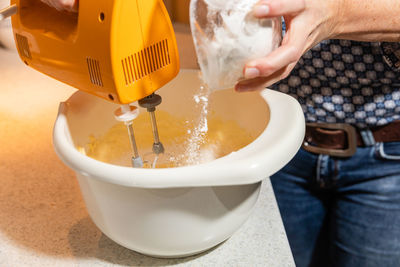 Close-up of hand pouring tea cup