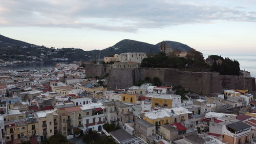 High angle view of townscape by sea against sky