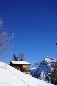 Snow covered houses against blue sky