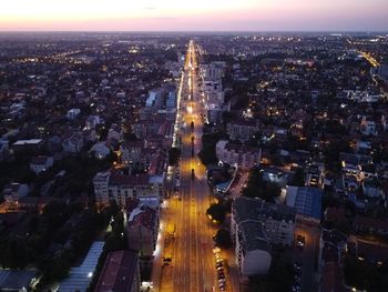 High angle view of illuminated cityscape against sky during sunset