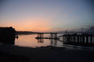 Silhouette pier on beach against sky during sunset