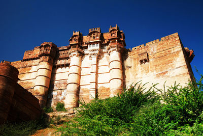 Low angle view of mehrangarh fort against clear blue sky