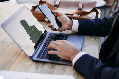 Businessman working with smart phone and laptop on table