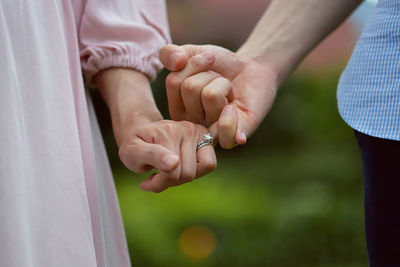 Midsection of couple holding hands