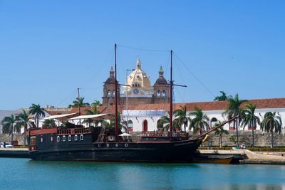 View of ship and building against blue sky