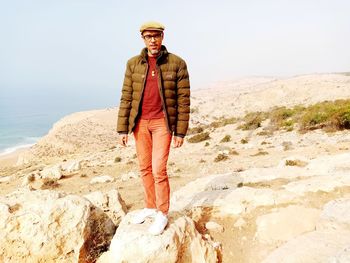 Portrait of man standing on rock at beach