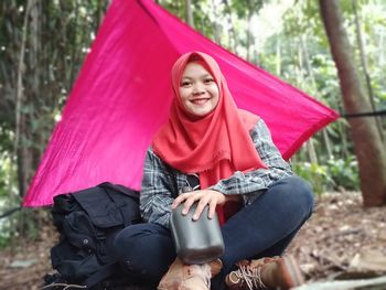 Portrait of smiling woman sitting on land