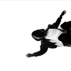 Low angle view of man playing guitar against white background