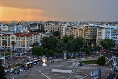 High angle view of vehicles on road by buildings in city