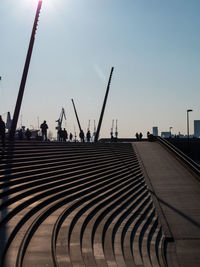 People at commercial dock against clear sky