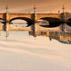 Bridge over river against sky during sunset