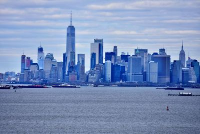 View of buildings in sea against cloudy sky