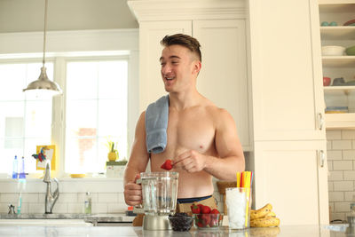 Smiling young man standing at home