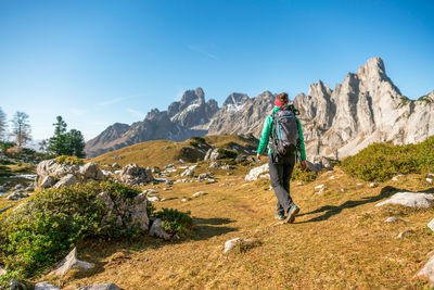 Rear view of man on rock against sky