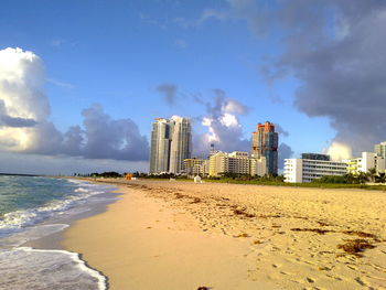 Sea and buildings against sky in city