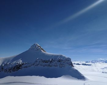 Scenic view of snowcapped mountain against blue sky