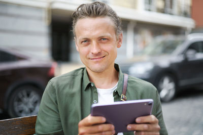 Young man using mobile phone in city