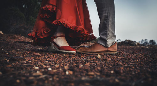 Low section of couple standing on pebbles