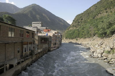 Scenic view of sea by buildings against sky