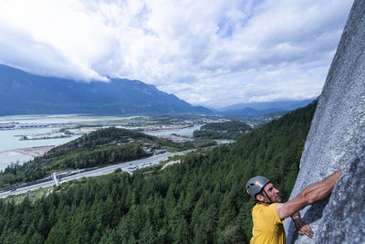 Man with arms raised in mountains against sky