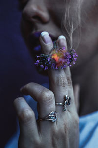 Close-up of hand holding purple flower