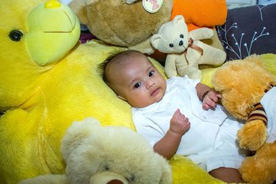 Cute baby boy lying on bed at home