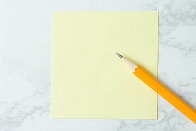 High angle view of yellow paper against white wall