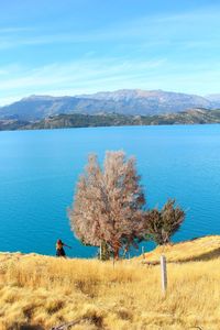 Scenic view of lake by mountains against sky